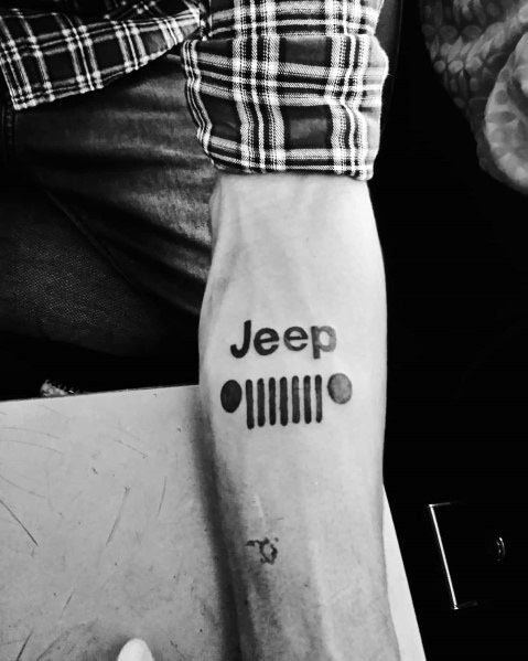 Minimalist black ink tattoo of the Jeep logo with the iconic seven-slot grille and round headlights, placed on the forearm for a clean design.