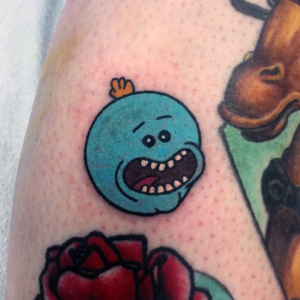Tattoo of Mr. Meeseeks' head from Rick and Morty with a distressed expression, placed among other colorful tattoos.