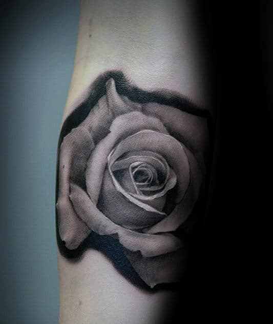 Black and gray tattoo of a rose on a  forearm