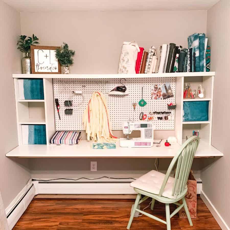 Charming sewing nook with a pegboard for tools, fabric shelves, a sewing machine, and decorative accents on a tidy desk