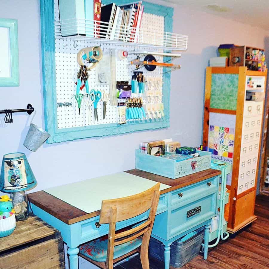 Creative sewing area with a blue desk, pegboard for tools, rolling cart, and decorative storage in a vibrant setup