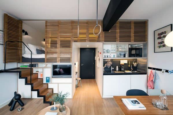 Modern studio with wooden slat partitions, a loft bed, and a sleek, compact kitchen design.