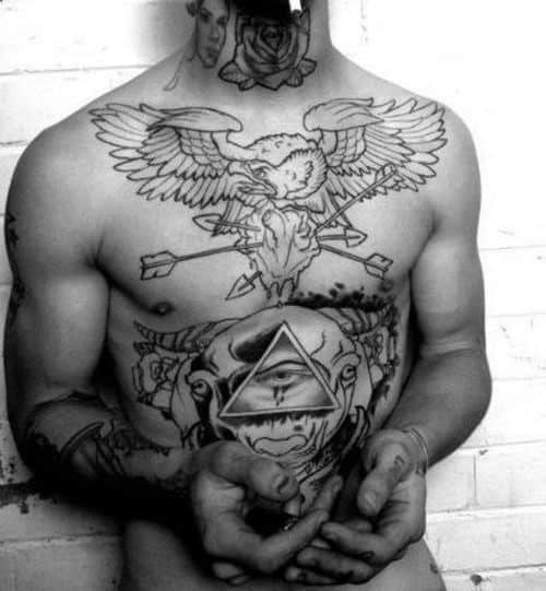 Tattooed torso featuring eagle, eye triangle, and various symbolic designs