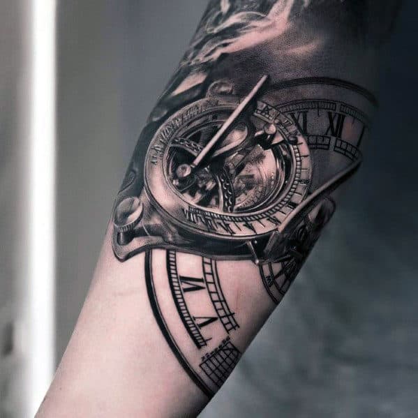 Tattoo of a detailed, realistic compass with Roman numerals on a person's forearm