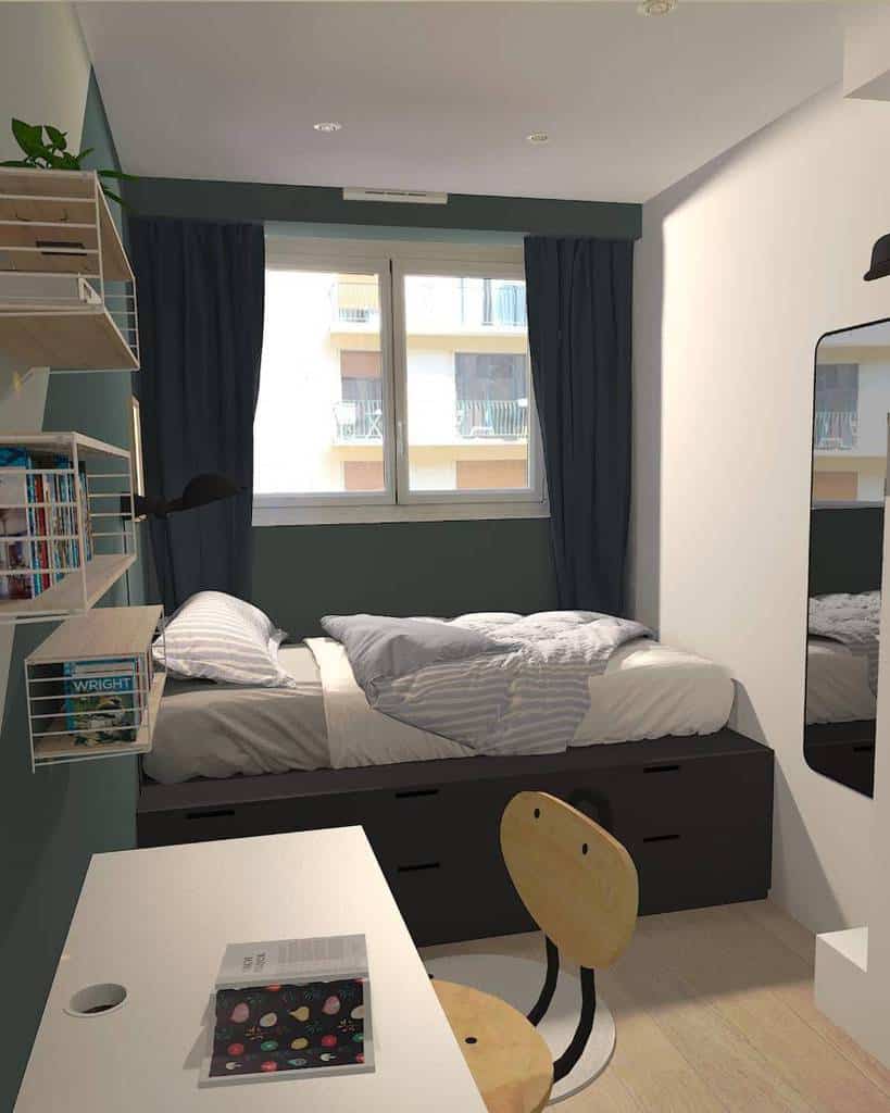Tiny college dorm bedroom with storage bed, desk, wall shelves, and large window for natural light.