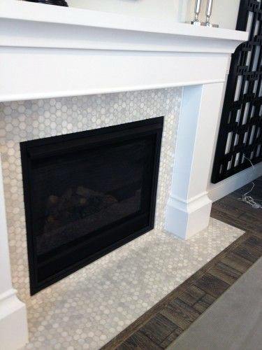 White fireplace with a classic wood mantel and a hexagon tile surround featuring a gas firebox.