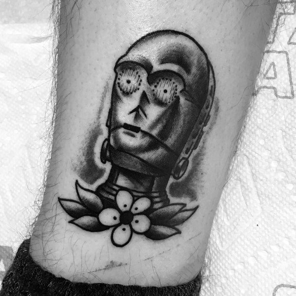 Black and grey C-3PO tattoo with bold outlines, soft shading, and floral accents, blending sci-fi with a neo-traditional tattoo style.