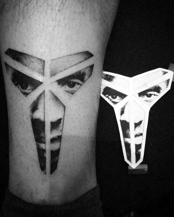 A creative tattoo featuring Kobe Bryant's "Mamba" logo with his face integrated into the geometric design, representing his iconic "Black Mamba" persona.