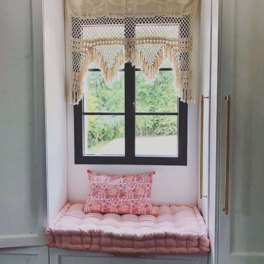 small window seat pink pillow black window frame