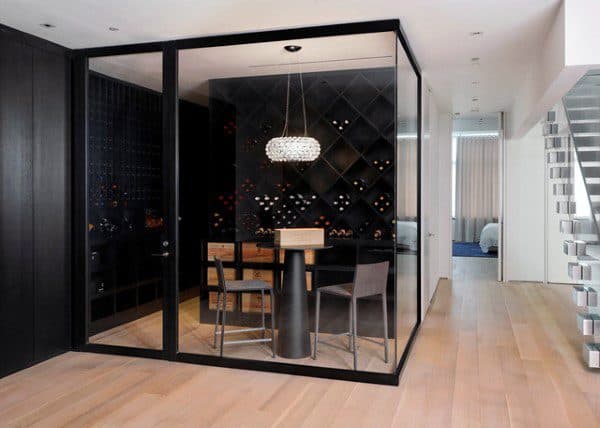 Modern glass-enclosed wine room with shelves, table, chairs, and chandelier; perfect for showcasing your wine collection