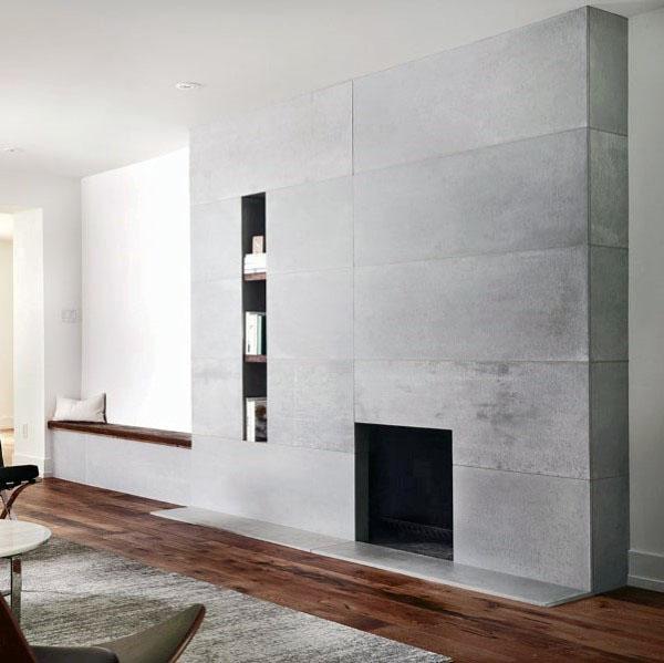 Modern grey concrete fireplace with integrated shelving, paired with warm hardwood flooring.