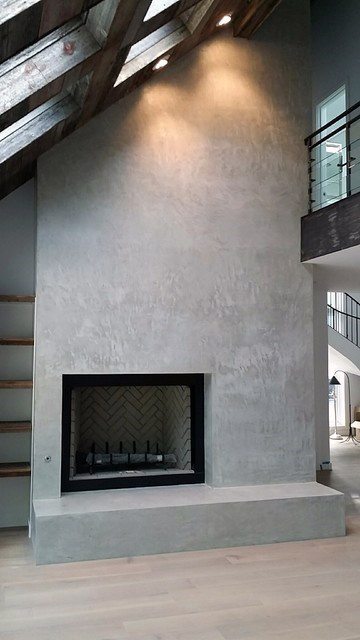 Smooth grey concrete fireplace with a minimalist aesthetic.