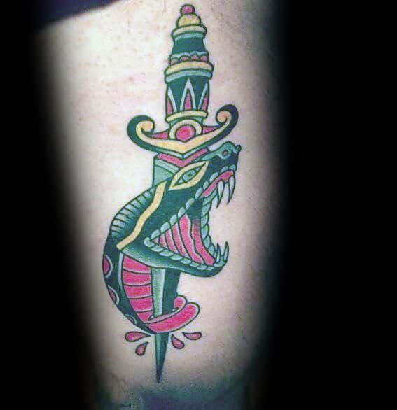 Traditional snake and dagger tattoo featuring bold green, red, and yellow ink with intricate details and classic old-school shading.