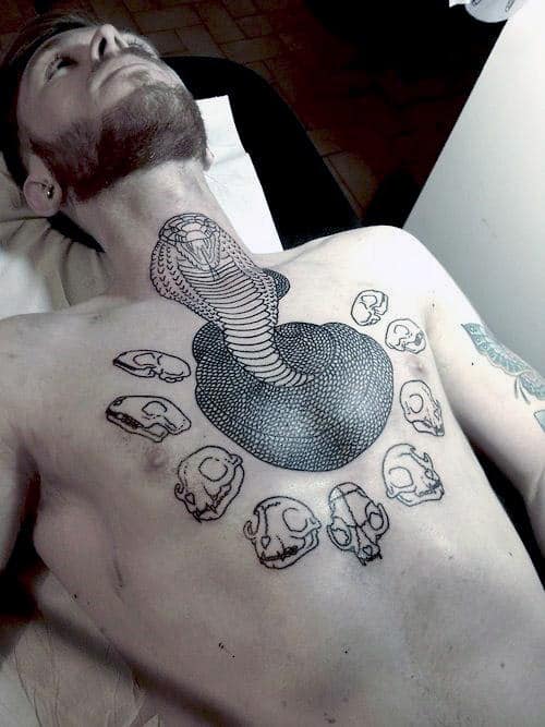 Person with a detailed cobra and skull tattoos on their chest