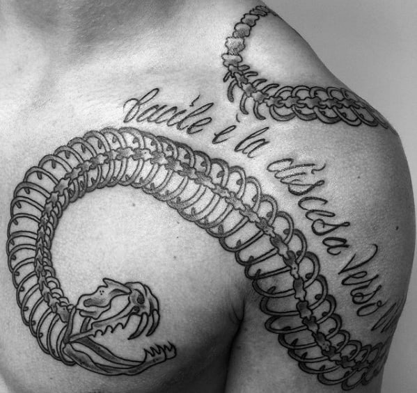 Snake skeleton tattoo wrapping around the chest and shoulder, featuring intricate rib details and cursive script for a bold and artistic design.
