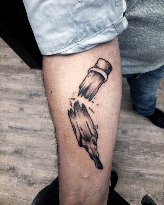 A tattoo of a shattered pencil elegantly adorns a person's forearm, capturing both the fragility and strength of creativity