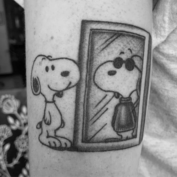 Black and white tattoo of Snoopy looking into a mirror, where his reflection shows him wearing sunglasses and a cool jacket.