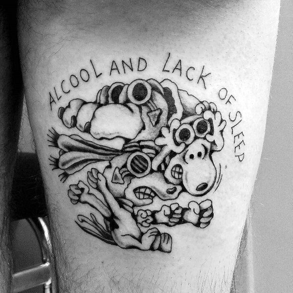 Black and white tattoo of a distorted Snoopy with exaggerated features, surrounded by the text "ALCOOL AND LACK OF SLEEP," placed on a leg.