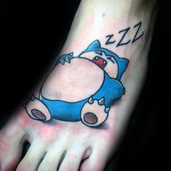 Snorlax tattoo on foot lying on its back, mouth open mid-snore with “ZZZ” above its head in a playful sleepy design.