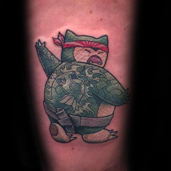 Tattoo of Snorlax dressed as a ninja with a red headband and full-body dragon tattoo, striking an action pose.