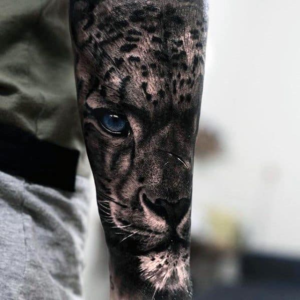 Ultra-realistic snow leopard tattoo sleeve with piercing blue eye, deep shadows, and lifelike fur texture wrapping around the forearm.
