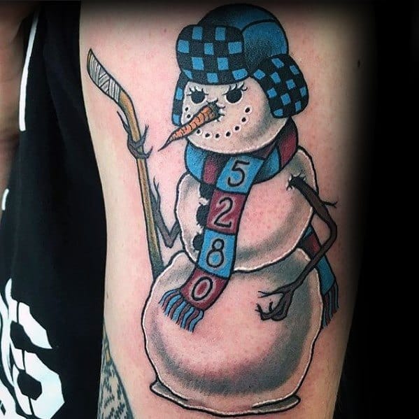 Hockey-themed snowman tattoo wearing a checkered winter hat and scarf, holding a hockey stick with twig arms, blending sports and winter charm.