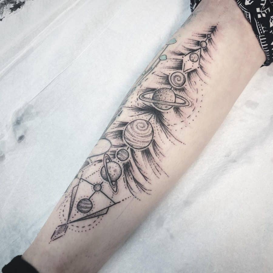 Forearm tattoo featuring a cosmic design with planets, geometric elements, and swirling details, creating a celestial and futuristic look.