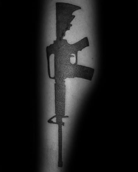 Solid black AR-15 silhouette tattoo on the forearm, featuring a bold and minimalist design, symbolizing strength, precision, and firearm appreciation.