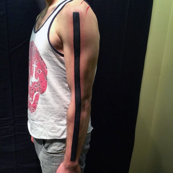 Man with a solid black stripe tattoo along his arm