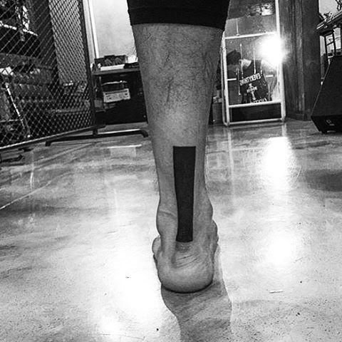 Black rectangle tattoo on the back of a calf