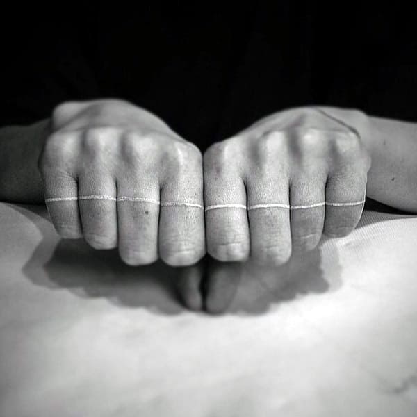 Solid White Ink Line Across Fingers On Mans Hand Tattoo