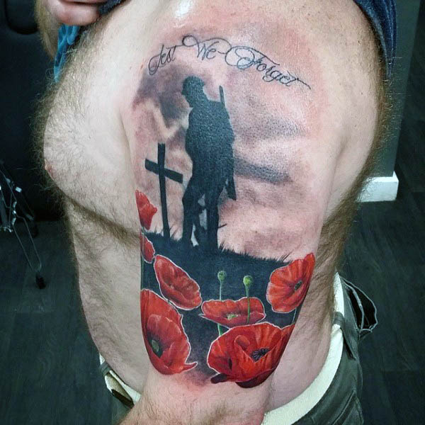 Solider Mourning Cross Grave With Poppy Flowers Tattoo On Upper Arm Of Man