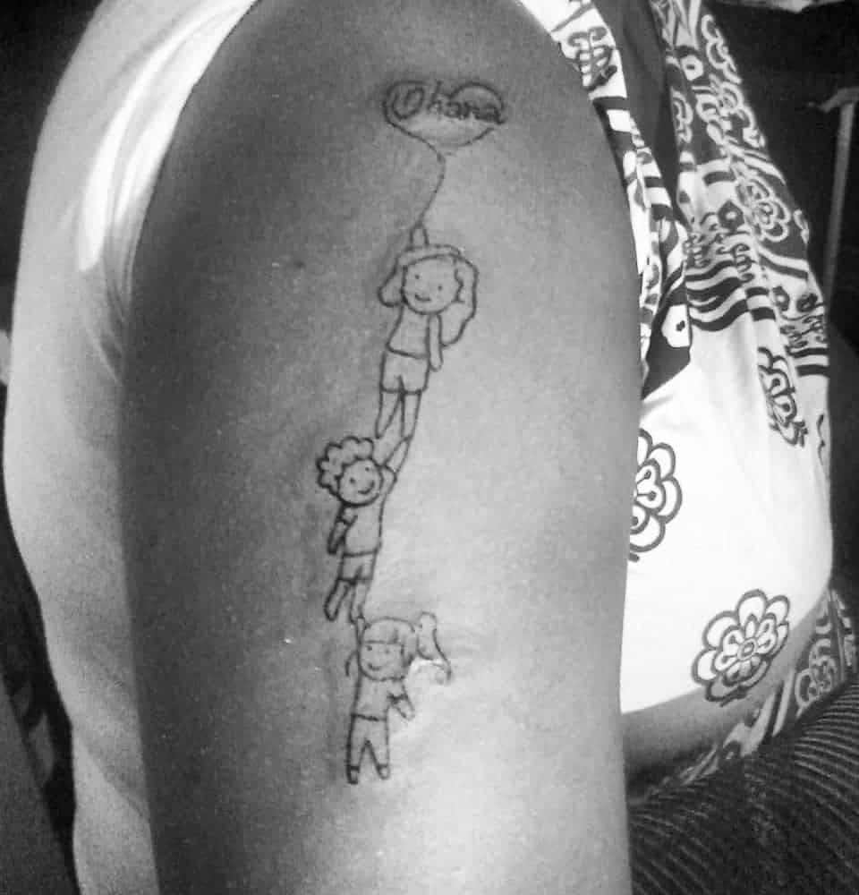 Playful 'Ohana' tattoo featuring children holding onto a balloon, symbolizing family, unity, and support.