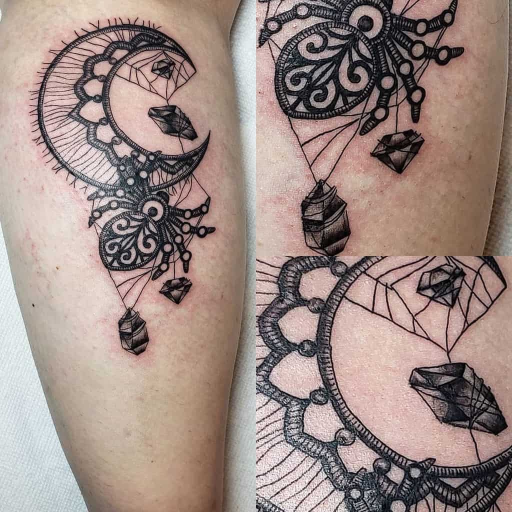 Ornate crescent moon tattoo with lace details, geometric crystals, and delicate linework, blending celestial and ornamental elements.