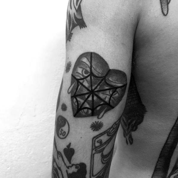 Blackwork heart tattoo featuring geometric spider web patterns overlaying a pair of mysterious eyes, creating a striking and surreal design on the arm