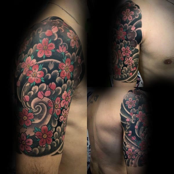 Japanese half-sleeve tattoo featuring vibrant cherry blossoms over bold black and grey spirals, creating a striking and dynamic design
