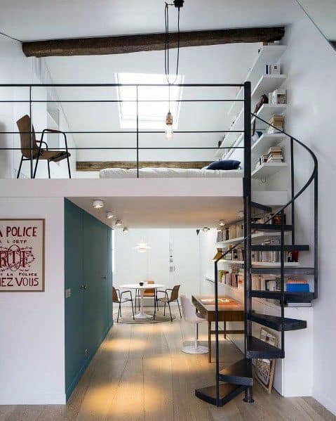 Loft apartment with spiral staircase, skylight, dining area, and wall-mounted bookshelf.