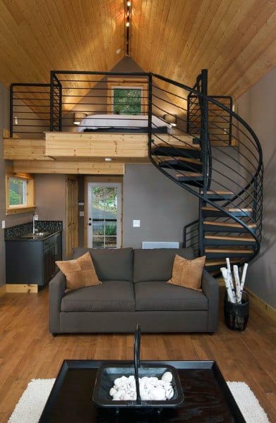Rustic loft with a cozy spiral staircase leading to a charming wooden bedroom area.