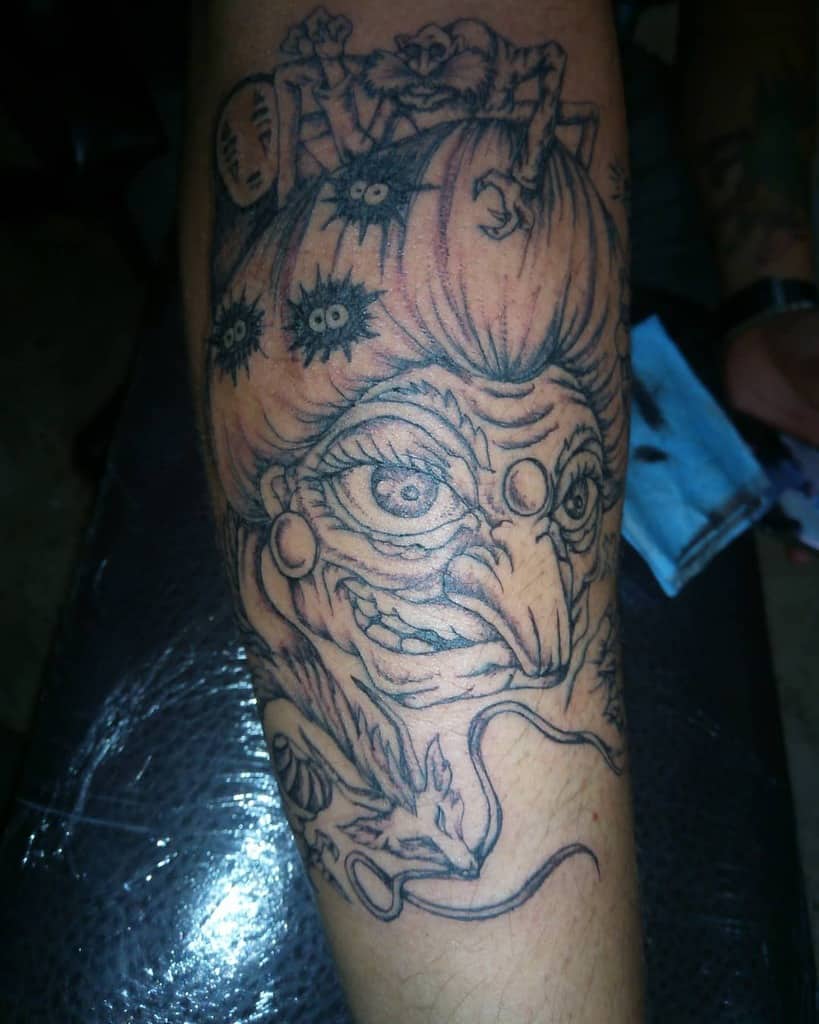 Detailed black and grey tattoo of Yubaba from Spirited Away, featuring soot sprites, No-Face, Haku in dragon form, and Kasuga-sama atop her hair