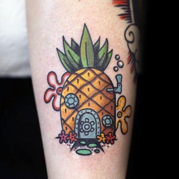 Colorful tattoo of SpongeBob’s iconic pineapple house with detailed windows, door, and flowers, set against underwater-themed background accents.
