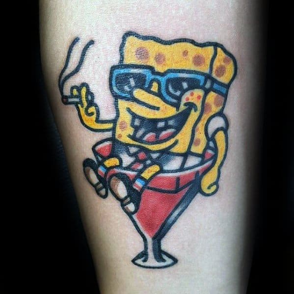 Bold tattoo of SpongeBob wearing sunglasses, relaxing in a cocktail glass, and holding a cigarette with a mischievous, carefree vibe.