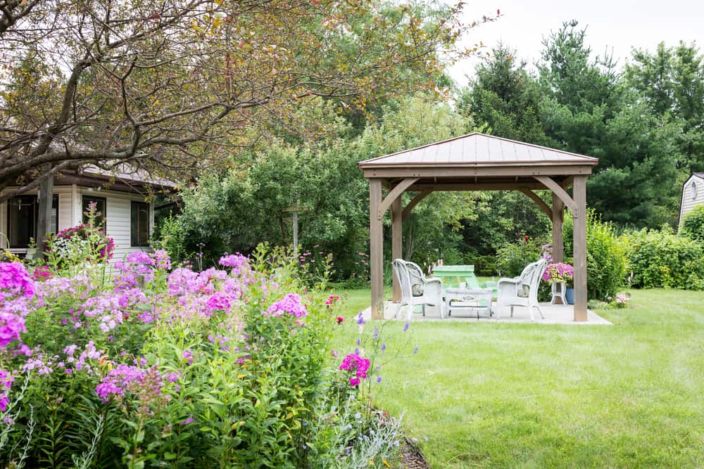 small square gazebo white wicker chair and table backyard