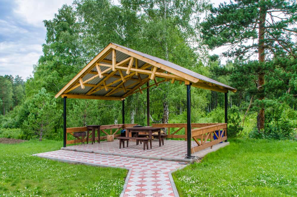 square metal and wood gazebo paved flooring wood bench seats