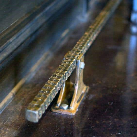 Square welded rebar foot rail with industrial-style brackets on a dark wooden bar surface.