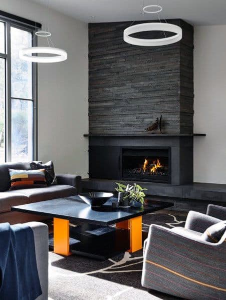 Modern living room with stacked stone fireplace, round lights, and black coffee table