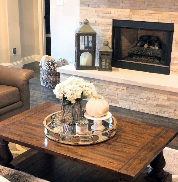 Cozy living room with a stacked stone fireplace, wooden coffee table, and decorative lanterns