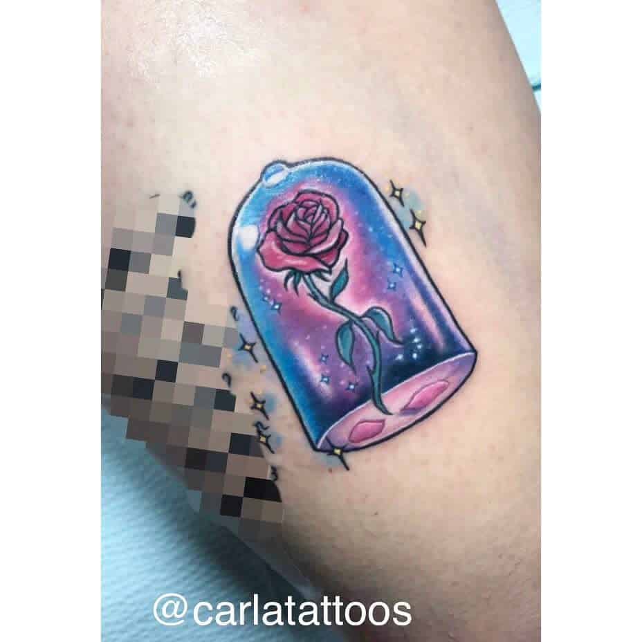 Vibrant Beauty and the Beast rose tattoo in a glass dome, with sparkling stars and soft, galaxy-like hues in the background