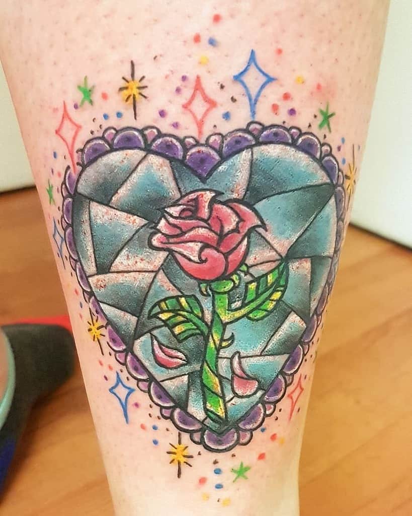 A vibrant stained glass heart featuring the Beauty and the Beast rose, with colorful stars adding a whimsical touch