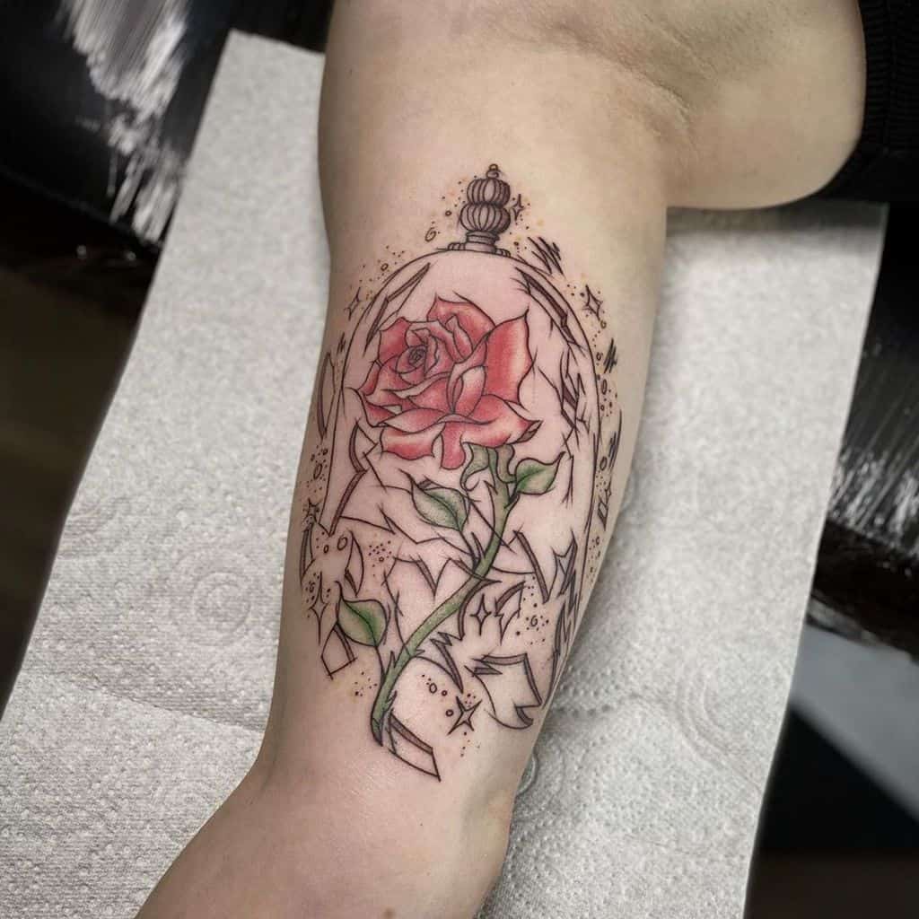 A vibrant Beauty and the Beast rose tattoo inside a glass dome, with shattered glass details, featuring bold red petals and green leaves