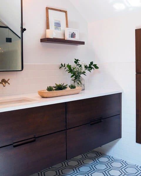 Stained wood floating vanity with white countertop and minimalist decor.